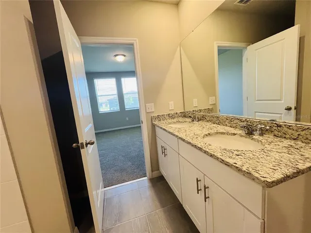 a bathroom with a granite countertop sink and a mirror