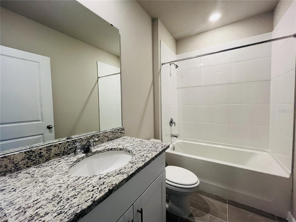 1061 Oak Vly Drive Auburndale, FL 33823 - Photo 13 of 16 a bathroom with a granite countertop sink toilet and shower