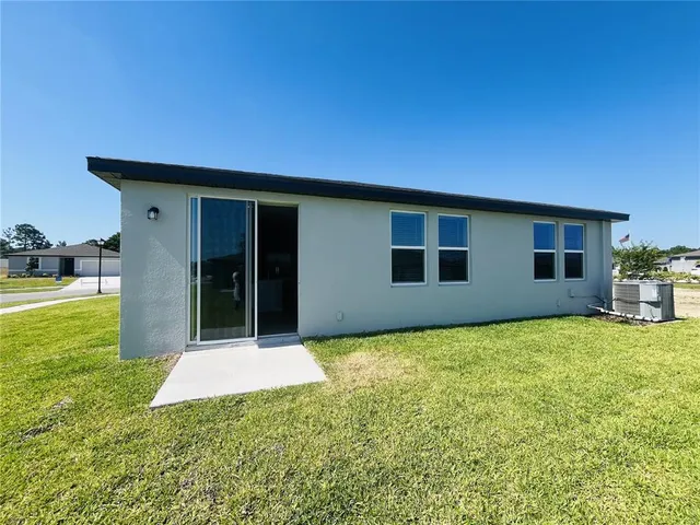 a backyard of a house with table and chairs