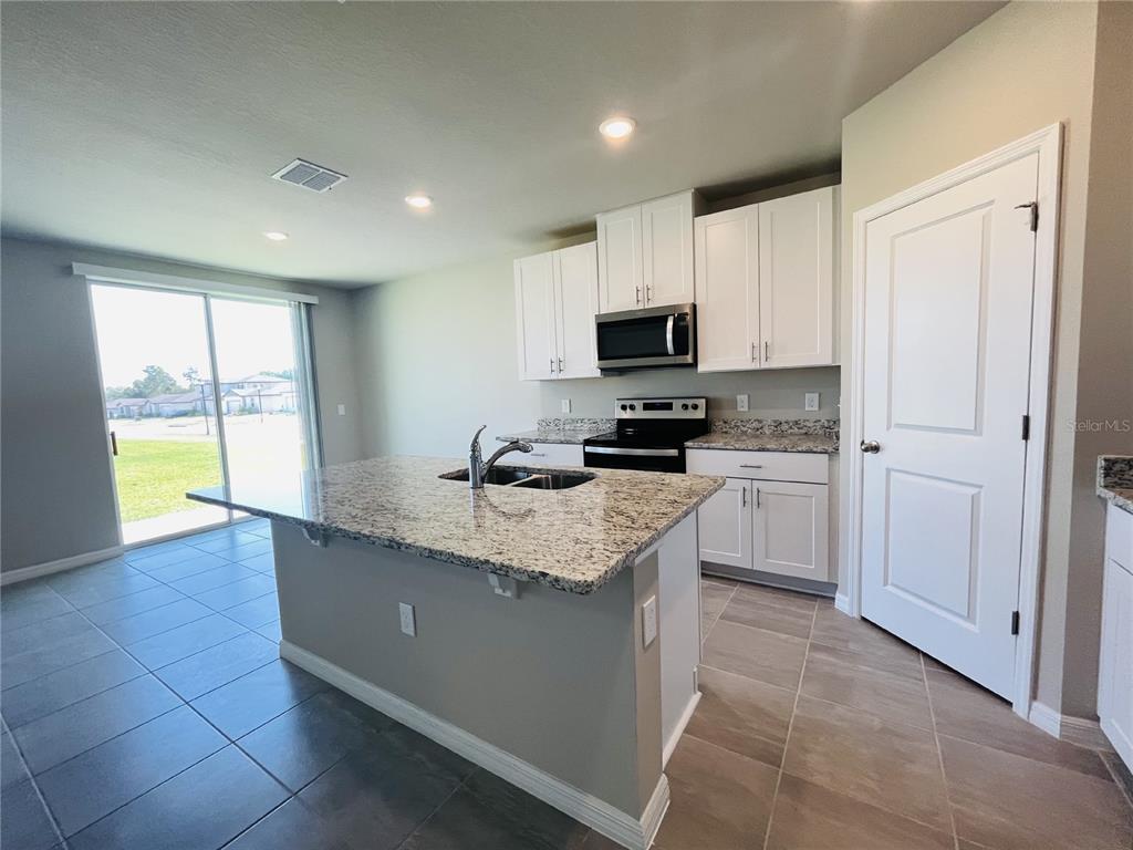 1061 Oak Vly Drive Auburndale, FL 33823 - Photo 5 of 16 a kitchen with appliances a sink a counter top space cabinets and a window