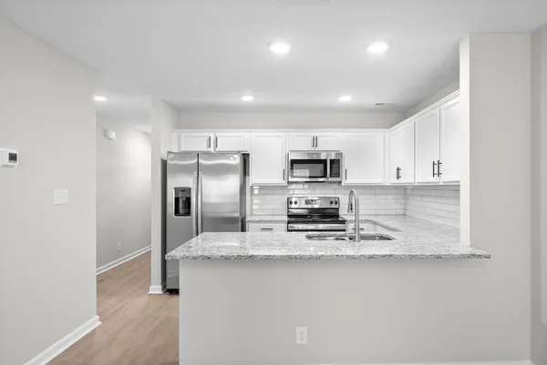 a kitchen with stainless steel appliances a sink and a refrigerator