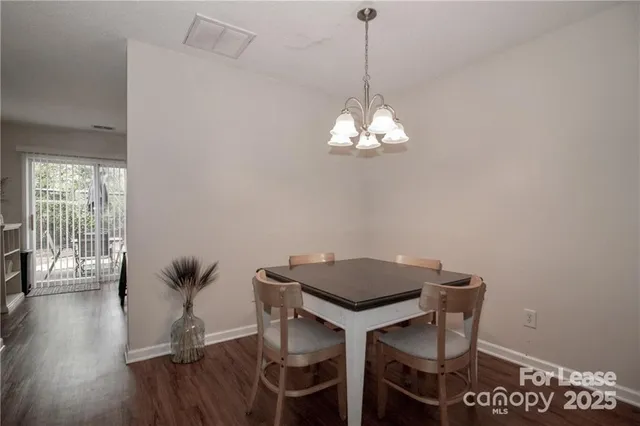 a view of a dining room with furniture wooden floor and chandelier
