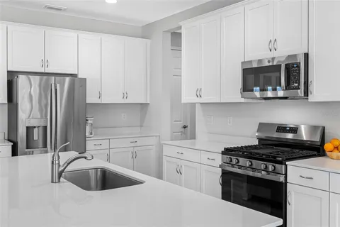 a kitchen with stainless steel appliances granite countertop a sink stove and refrigerator