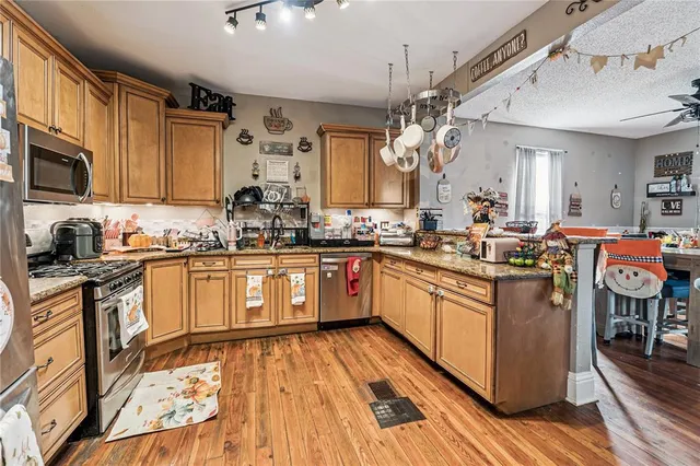 a kitchen with a sink stove cabinets and wooden floor