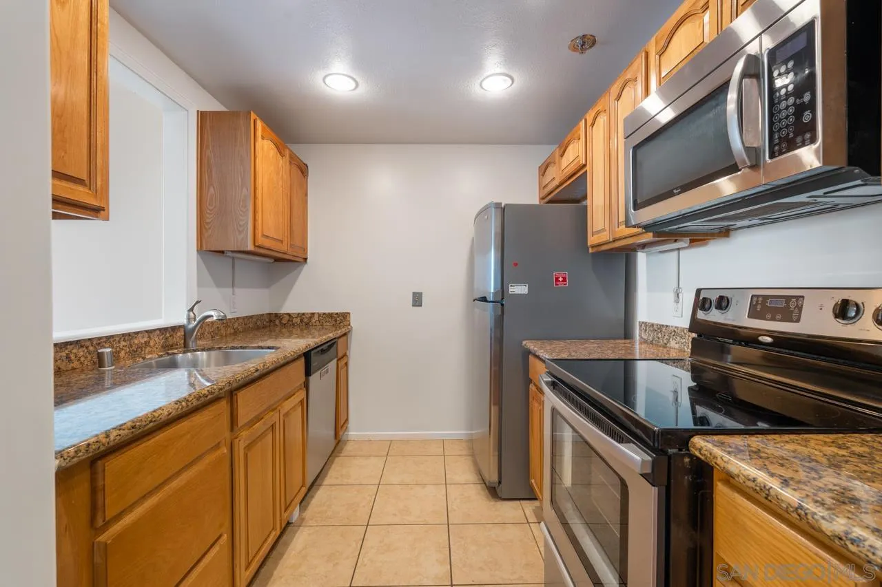 3890 Nobel, Unit 1205 San Diego, CA 92122 - Photo 2 of 19 a kitchen with stainless steel appliances granite countertop a sink stove and refrigerator