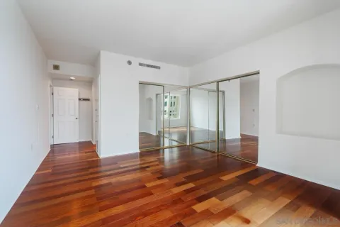 a view of an empty room with wooden floor