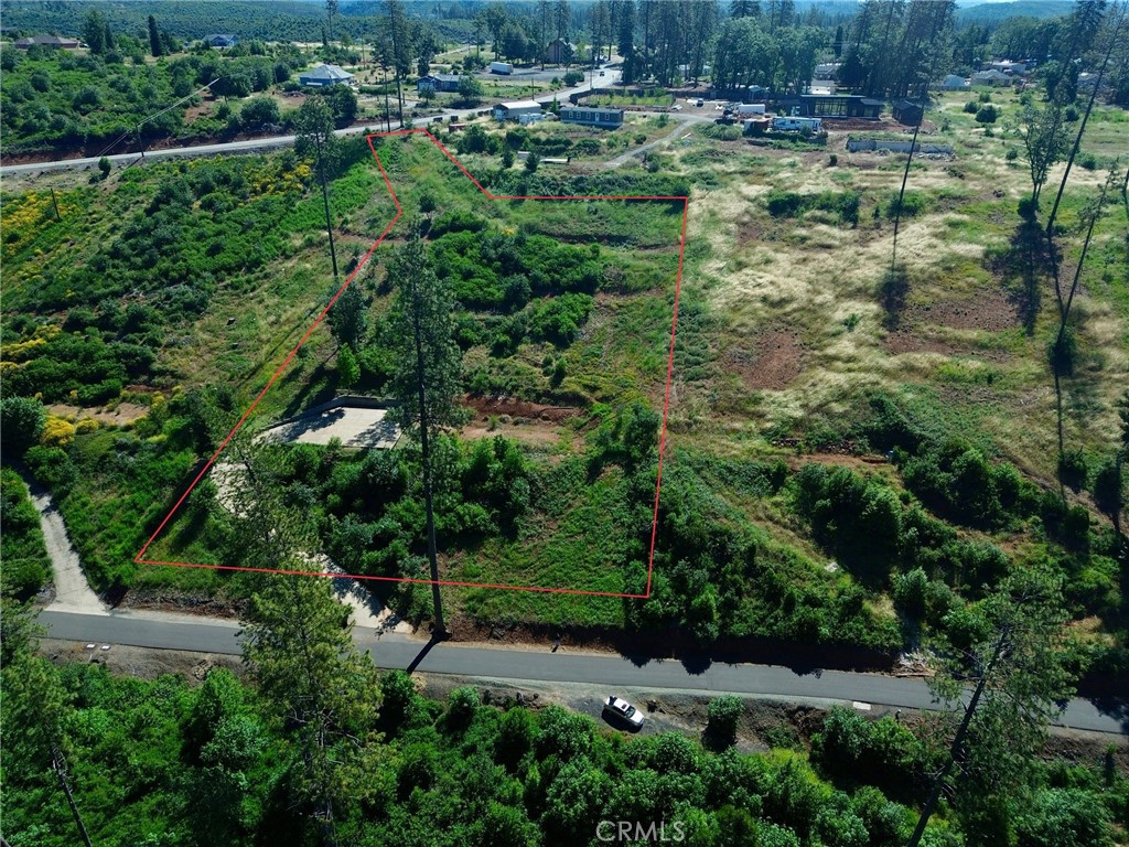 an aerial view of residential house with outdoor space and trees all around
