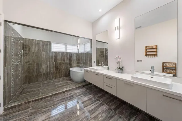 a bathroom with a double vanity sink mirror and shower