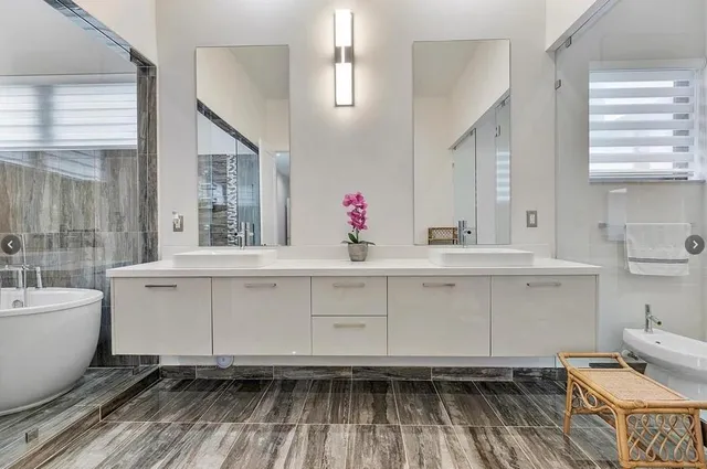 a bathroom with a sink a toilet a mirror a vanity and shower
