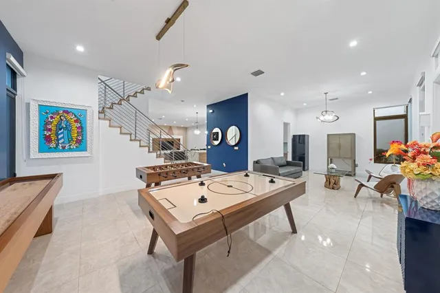 a living room with furniture a chandelier and a flat screen tv