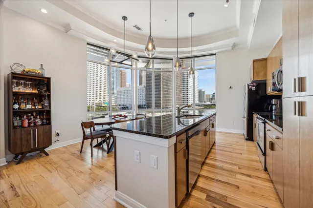 a kitchen with granite countertop a sink a counter top space appliances and cabinets