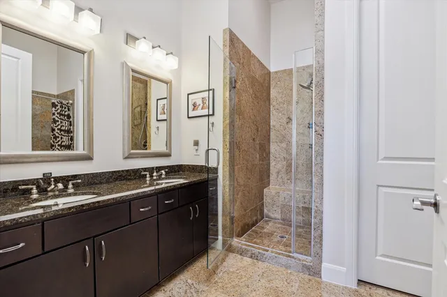 a bathroom with double vanity and a shower