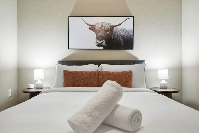 a bedroom with a bed and painting on the wall