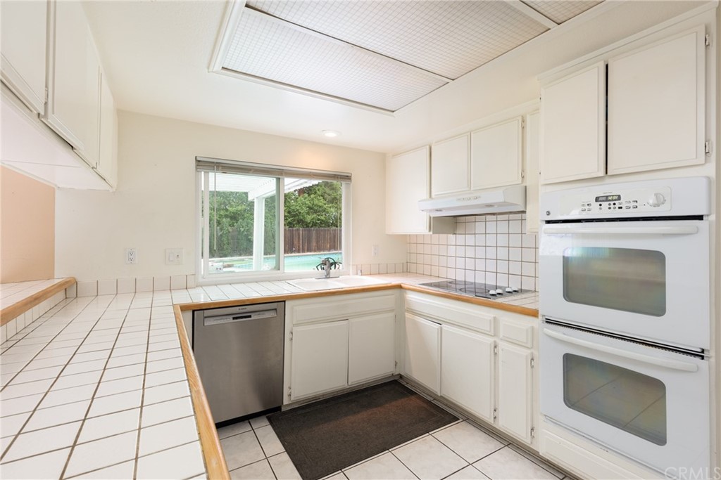 61 Sparrowhawk Irvine, CA 92604 - Photo 19 of 29 a kitchen with stainless steel appliances a stove sink and cabinets