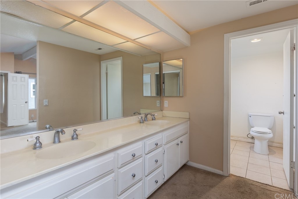 61 Sparrowhawk Irvine, CA 92604 - Photo 23 of 29 a bathroom with a granite countertop sink mirror and toilet
