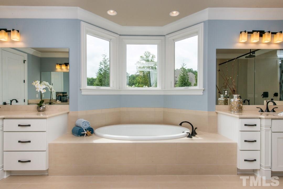 11005 Soco Gap Court Raleigh, NC 27613 - Photo 13 of 25 a white bath tub sitting in a bathroom next to a window