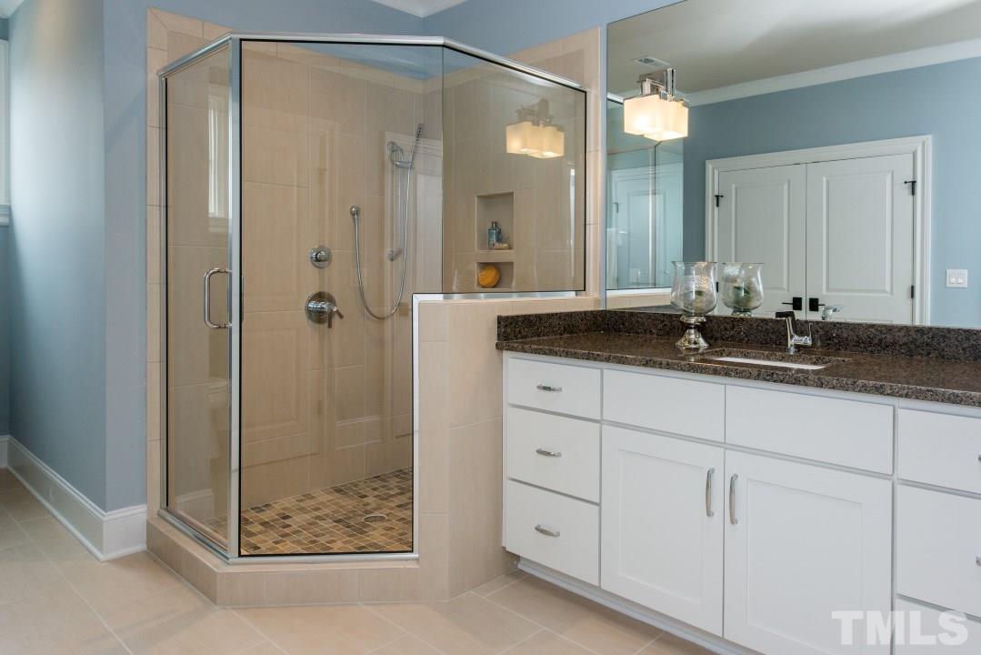 11005 Soco Gap Court Raleigh, NC 27613 - Photo 17 of 25 a bathroom with a shower sink and mirror