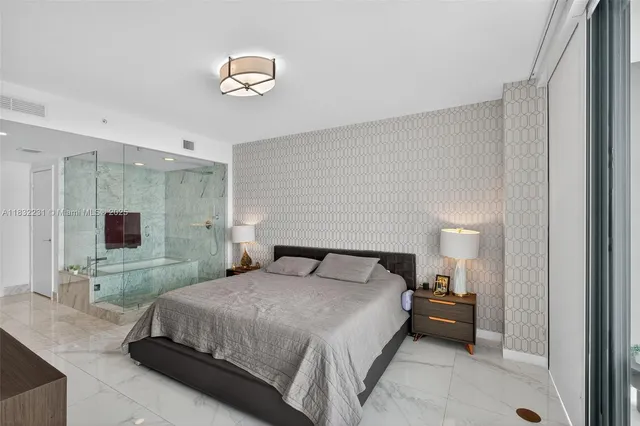 a bedroom with a bed and a flat tv screen on dresser