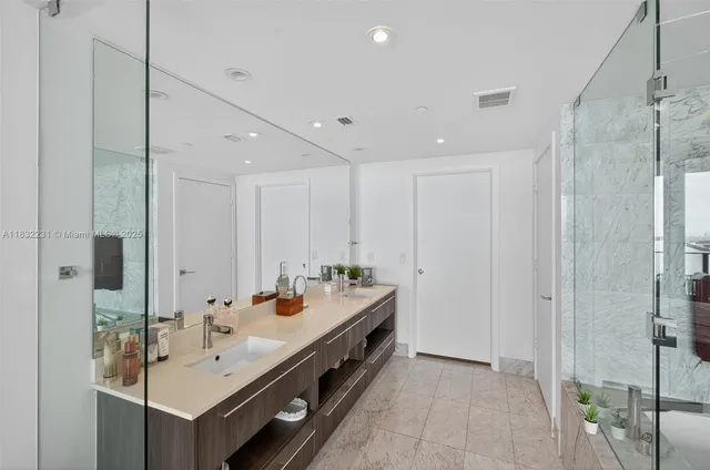 a bathroom with a double vanity sink mirror and shower