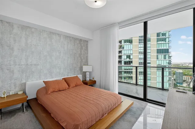 a bedroom with a bed and a flat tv screen on the dresser