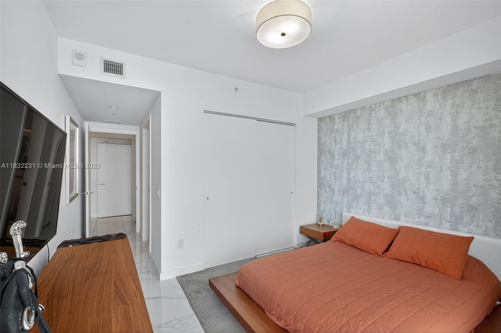 3131 Northeast 7th Avenue, Unit 4503 Miami, FL 33137 - Photo 30 of 51 a bedroom with a bed and a flat tv screen on the dresser