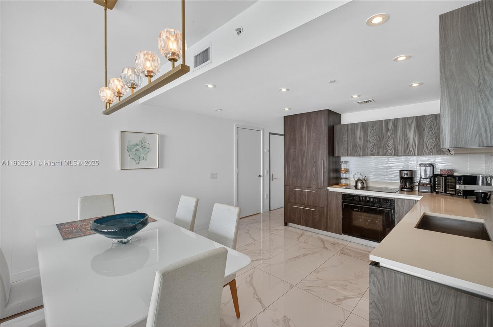 3131 Northeast 7th Avenue, Unit 4503 Miami, FL 33137 - Photo 8 of 51 a kitchen with stainless steel appliances a sink a stove a refrigerator cabinets and chairs