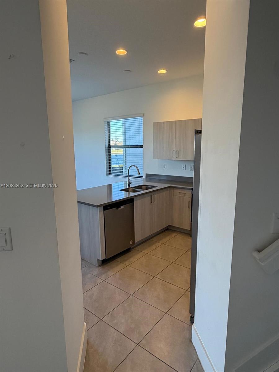 5669 Cerva Lane, Unit 5669 Immokalee, FL 34142 - Photo 26 of 32 a kitchen with stainless steel appliances granite countertop a sink and a stove top oven