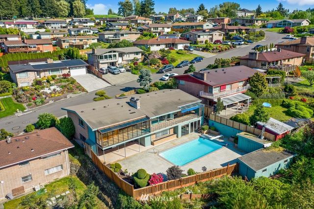 an aerial view of residential houses with outdoor space and parking