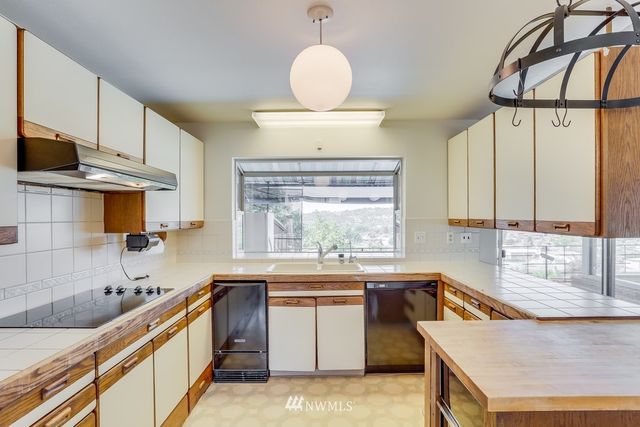 a kitchen with stainless steel appliances granite countertop a sink a stove and a wooden floors