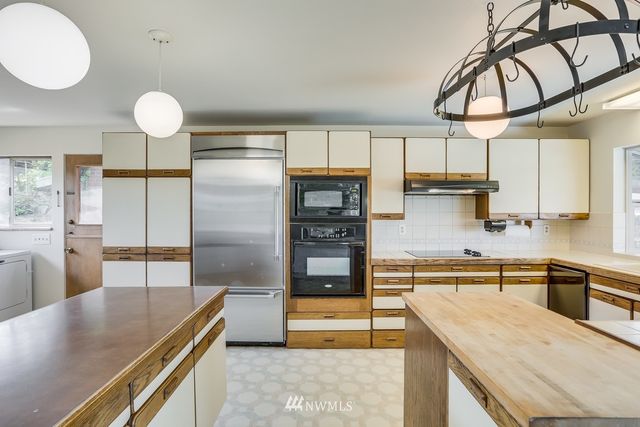 a kitchen with stainless steel appliances granite countertop a sink a stove and a refrigerator
