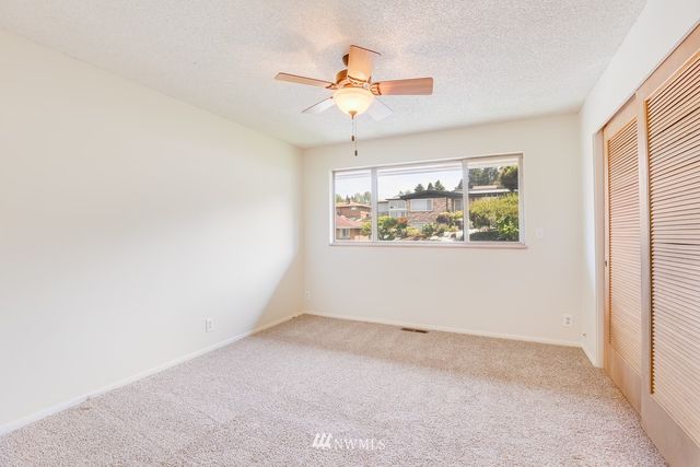 en empty room with window and ceiling fan