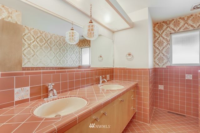 a bathroom with a granite countertop sink a mirror and a bathtub