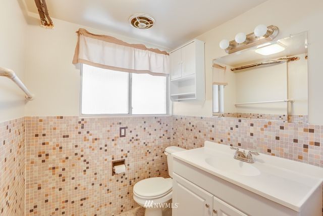 a bathroom with a sink a toilet and shower curtain
