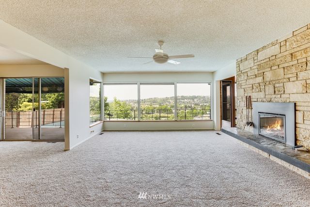 a view of an empty room with a fireplace and a window