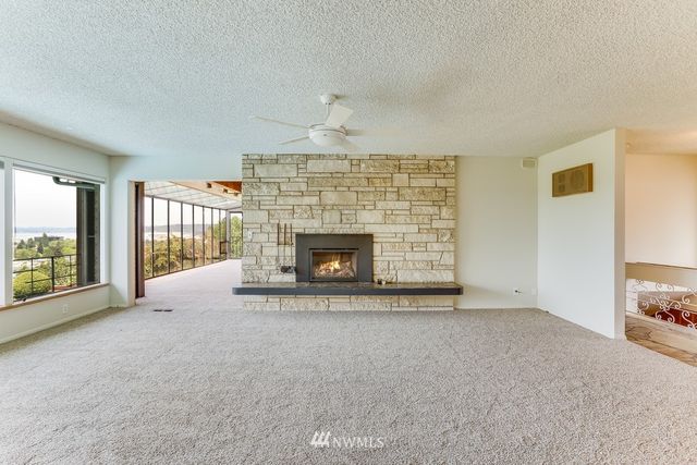 a view of an empty room with a fireplace and a window