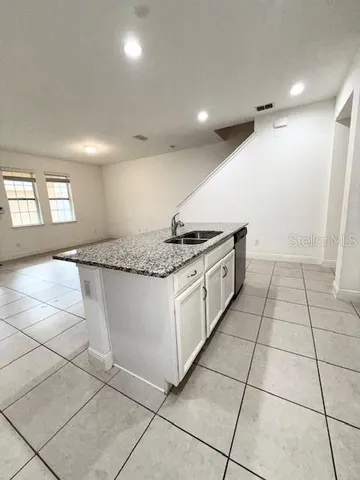 a kitchen with granite countertop white cabinets a sink and white appliances