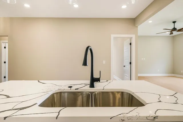 a kitchen with a sink a center island wooden floor and a chandelier
