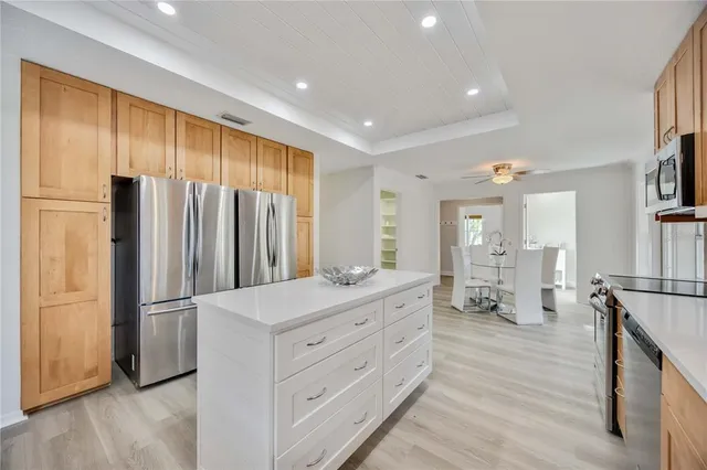 a kitchen with stainless steel appliances a refrigerator sink and cabinets
