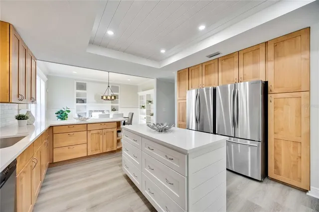 a large kitchen with cabinets stainless steel appliances and a window
