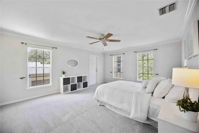 a bedroom with a large bed and a ceiling fan