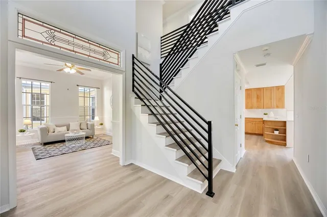 a hallway with a white couches next to a large window with wooden floor