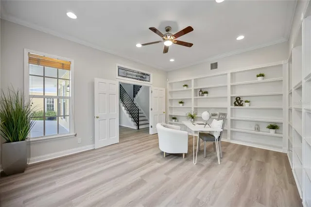 a living room with furniture and a large window with wooden floor