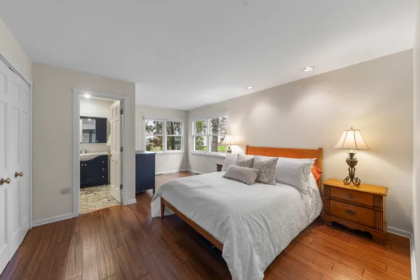 a bedroom with a bed and a wooden floor