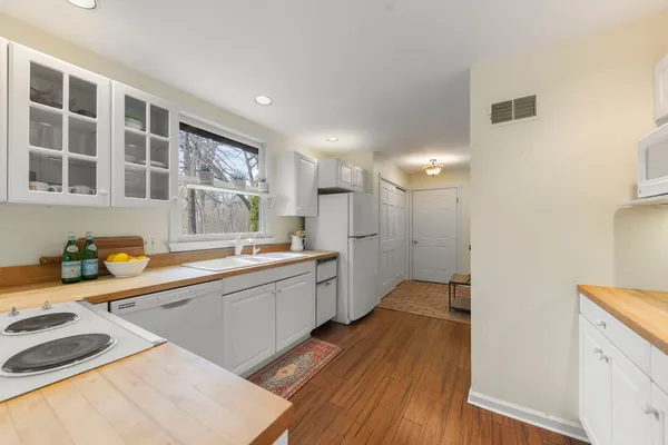 a large kitchen with a sink and wooden floor