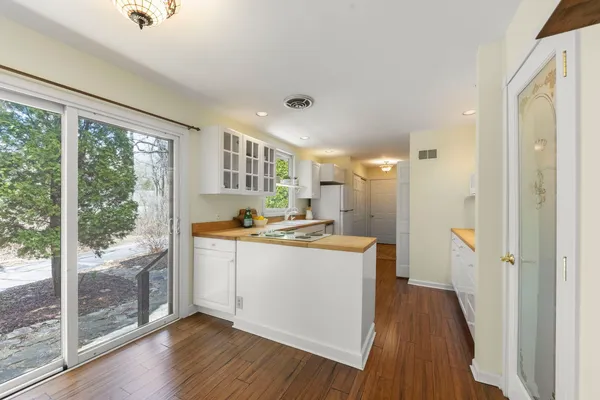 a kitchen with a refrigerator a sink and wooden floor