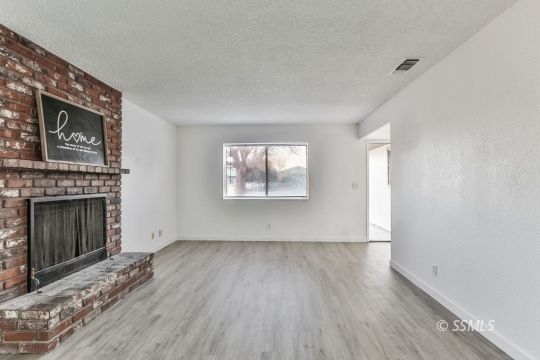 922 West Wasp Avenue Ridgecrest, CA 93555 - Photo 2 of 31 a view of empty room with wooden floor and fireplace