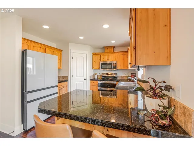 a kitchen with stainless steel appliances granite countertop a stove microwave and cabinets