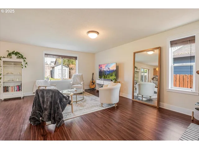 a living room with furniture flat screen tv and wooden floor