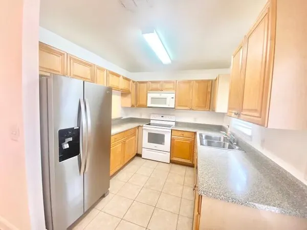 a kitchen with stainless steel appliances granite countertop a refrigerator and a sink