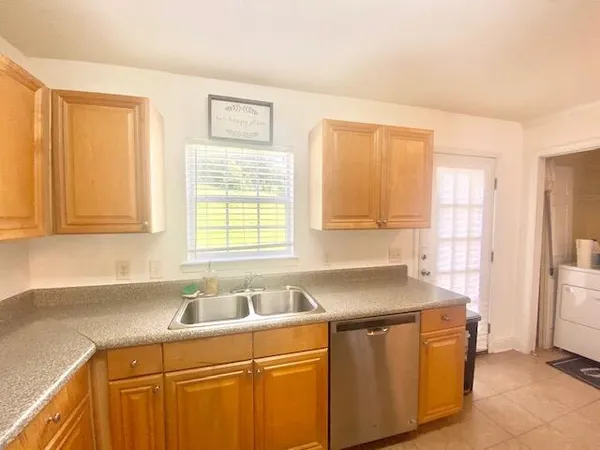 a kitchen with stainless steel appliances granite countertop a sink dishwasher a refrigerator and cabinets with wooden floor